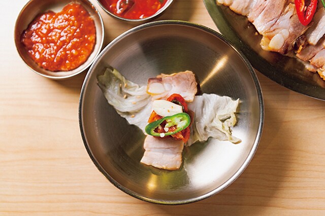 白菜キムチを広げ、豚肉、ジャン、大根キムチ、青唐辛子とネギの順に重ねる。