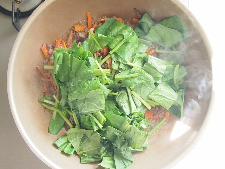 水分がなくなってきたら、水切りをしたほうれん草を入れてしんなりするまで炒める。