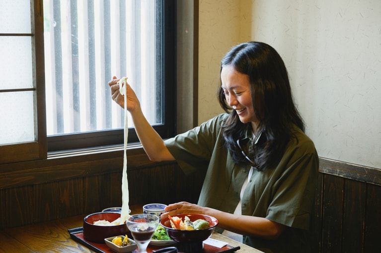 幅に加えて長さがあるのも特徴。箸でそっと持ち上げると、するりと伸びる長いうどんに吉岡さんも驚き。