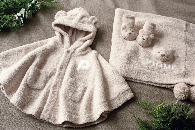 立体的なベアの顔に思わず笑みがこぼれるパウダーベアシリーズはセットで贈りたい。（左）フードについた立体的なベアの耳が愛らしい。BABYパウダーベアポンチョ 7,260円 ベージュはオンライン限定カラー。2025年2月中旬よりジェラート ピケ全店舗にて発売予定、（中央）足元についたふわふわのベアは存在感も抜群。BABYパウダーベアソックス 2,860円、（右）さらふわの肌触りが大切なベビーの身体を包み込んでくれる。KIDSパウダーベアブランケット 4,620円。※2024年12月6日現在。