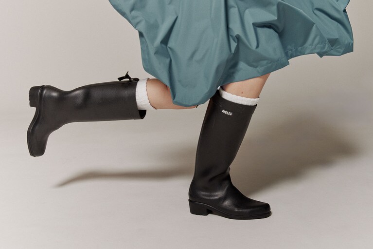 ゆったりとしたシルエットのポンチョにはエレガントなロングシルエットのロングブーツを。突然の雨でもへっちゃらだ。