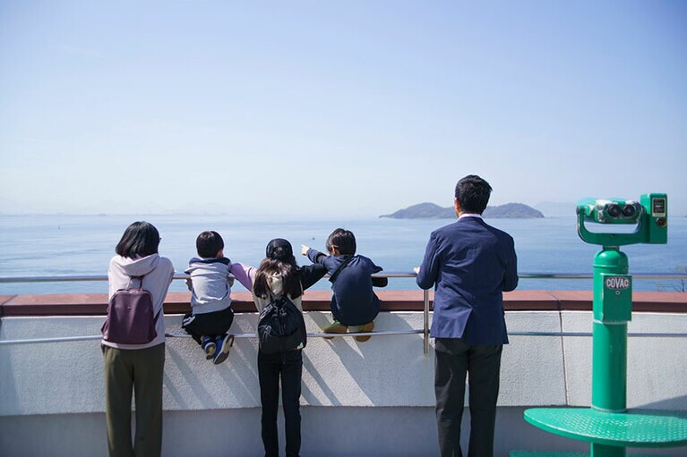 与島パーキングエリアから見える絶景。構内には瀬戸大橋列車通過時刻表が掲示される。