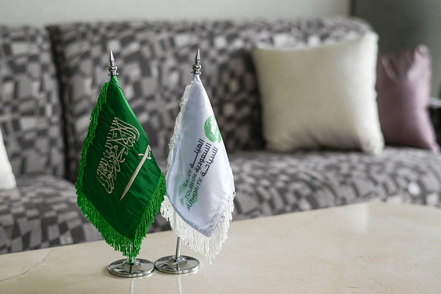 左から、聖句と刀が描かれたサウジアラビア王国の国旗と、政府観光局の旗。