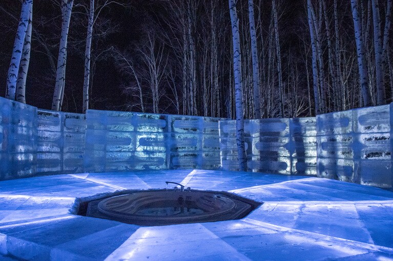 「氷のホテル」には白樺の森に囲まれた「氷の露天風呂」も完備。地元、湯の沢温泉から汲み上げた温泉で、冷えた身体をじんわりと芯から温めることができる。