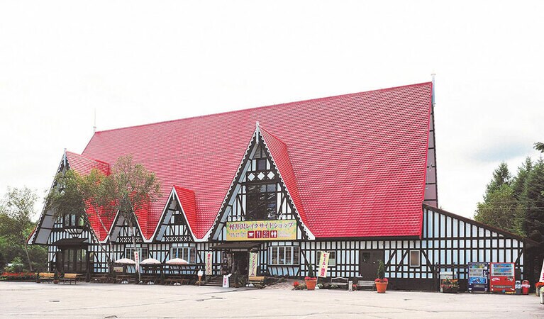 地元の土産物や高原野菜の販売、焼き立てパンを提供するベーカリーカフェ「コパン」を営業している軽井沢レイクサイドショップ。赤い三角屋根が目印。