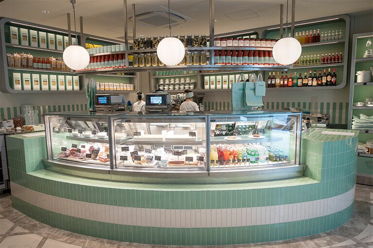 ピスタチオグリーンのオリジナルタイルで彩られたデリカテッセンのカウンター。