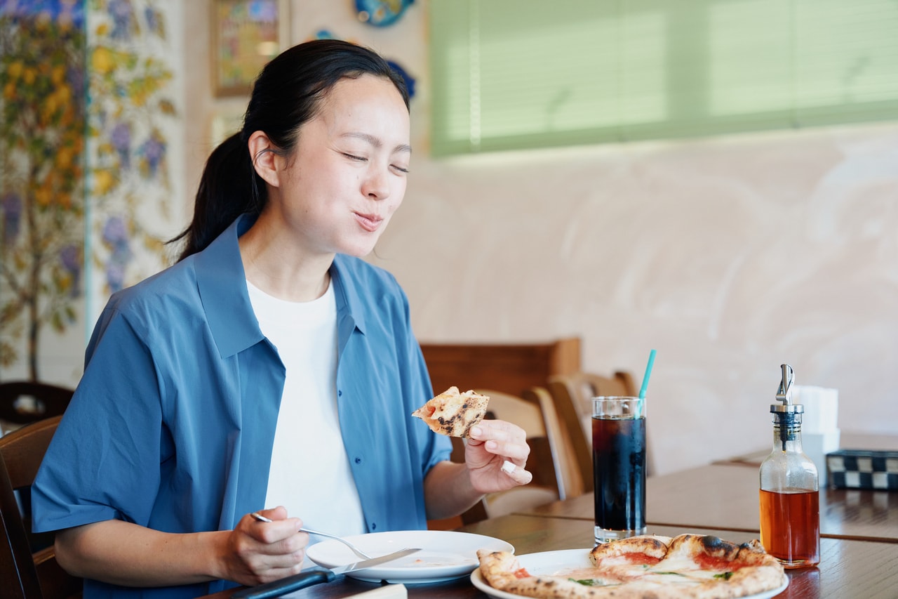 香ばしく焼き上がった熱々のピッツァを、うれしそうに頬張る吉岡さん。