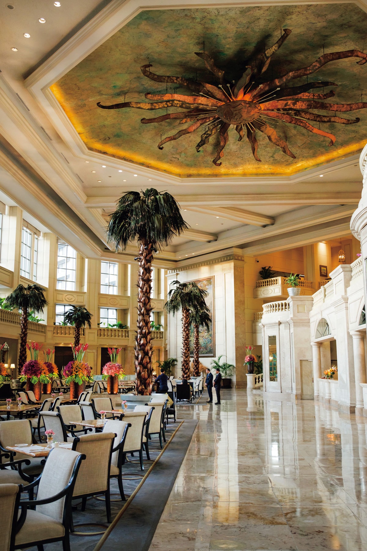 吹き抜けの高い天井から巨大な太陽の彫刻が見守るザ・ペニンシュラマニラの「ザ・ロビー」。