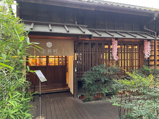 格子窓や引き戸の扉が和のテイストを演出しています。店舗前の緑とのコントラストも趣があり、撮影スポットとしても人気です。