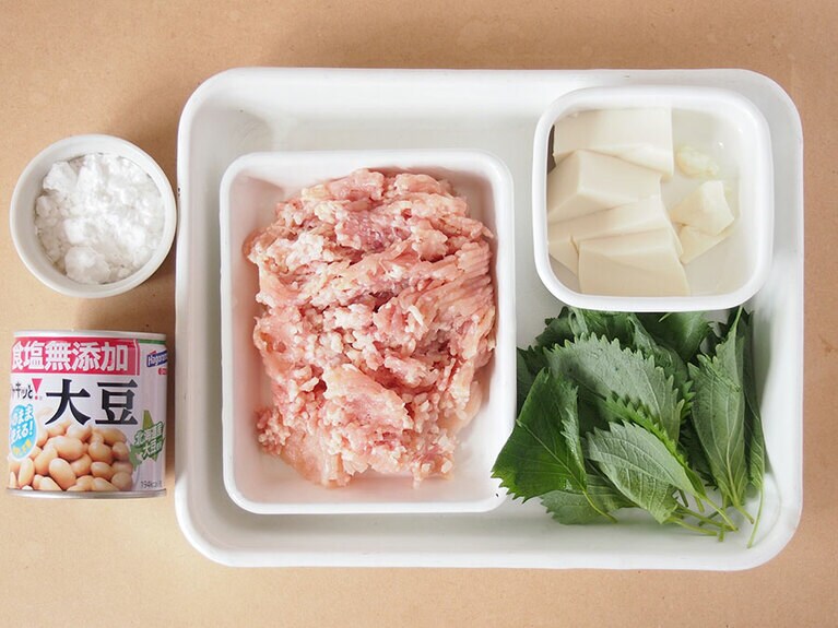 材料(4人前)。鶏ひき肉：250g／大豆水煮缶：1缶(120g)／豆腐：100g／大葉：20枚／ごま油：適量／ ［A］片栗粉：大さじ1／調理酒：小さじ2／醤油：小さじ1／味噌：小さじ1／ごま油：小さじ1／塩胡椒：少々。