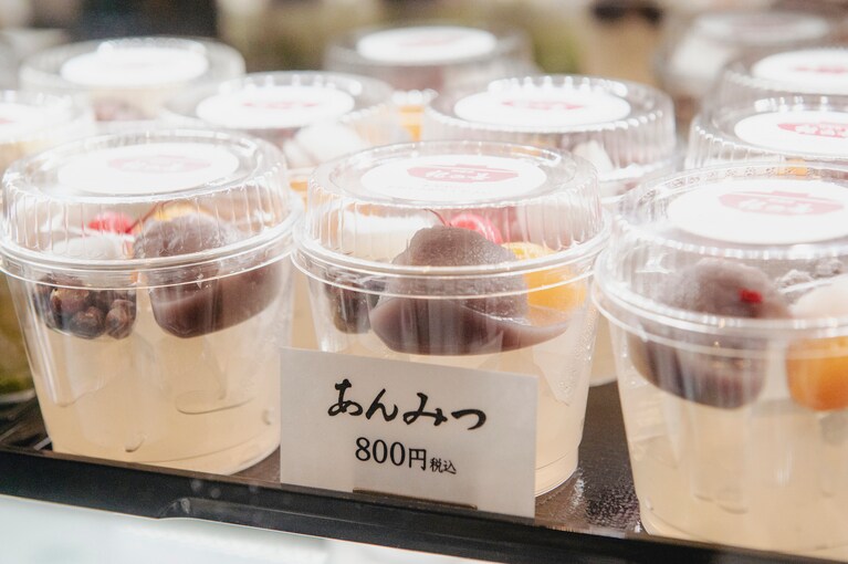 レジの下の冷蔵ケースにはお持ち帰り用の各種あんみつや豆かん、抹茶ババロア、白玉ぜんざいなどがずらり。いずれも店内価格の100円引きでお持ち帰りできる。