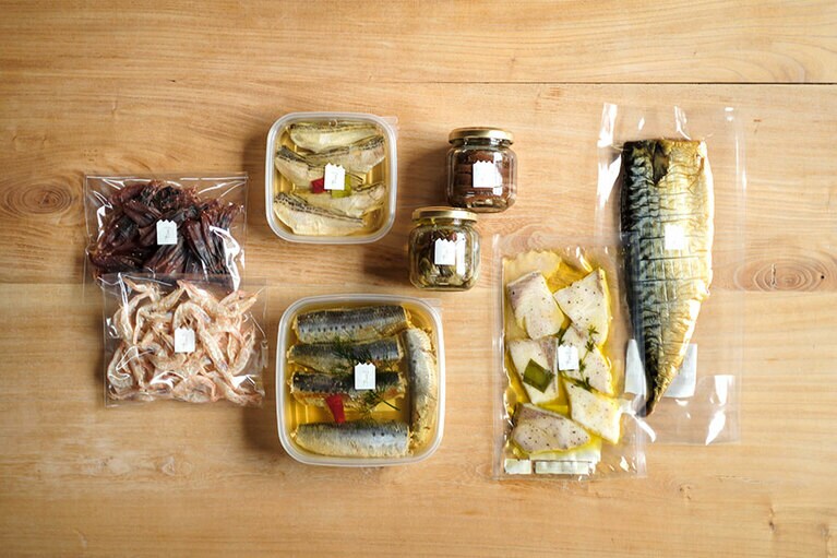 右からさば燻製(温燻)国産 734円、天然ぶりのコンフィ 864円、かき燻製オイル漬け 918円、糠いわしアンチョビ 1,512円、真いわしオイル漬け 1,296円、はたはたオイル漬け(小) 734円、白えび素干し 648円、ほたるいか素干し(酒粕漬け) 680円。