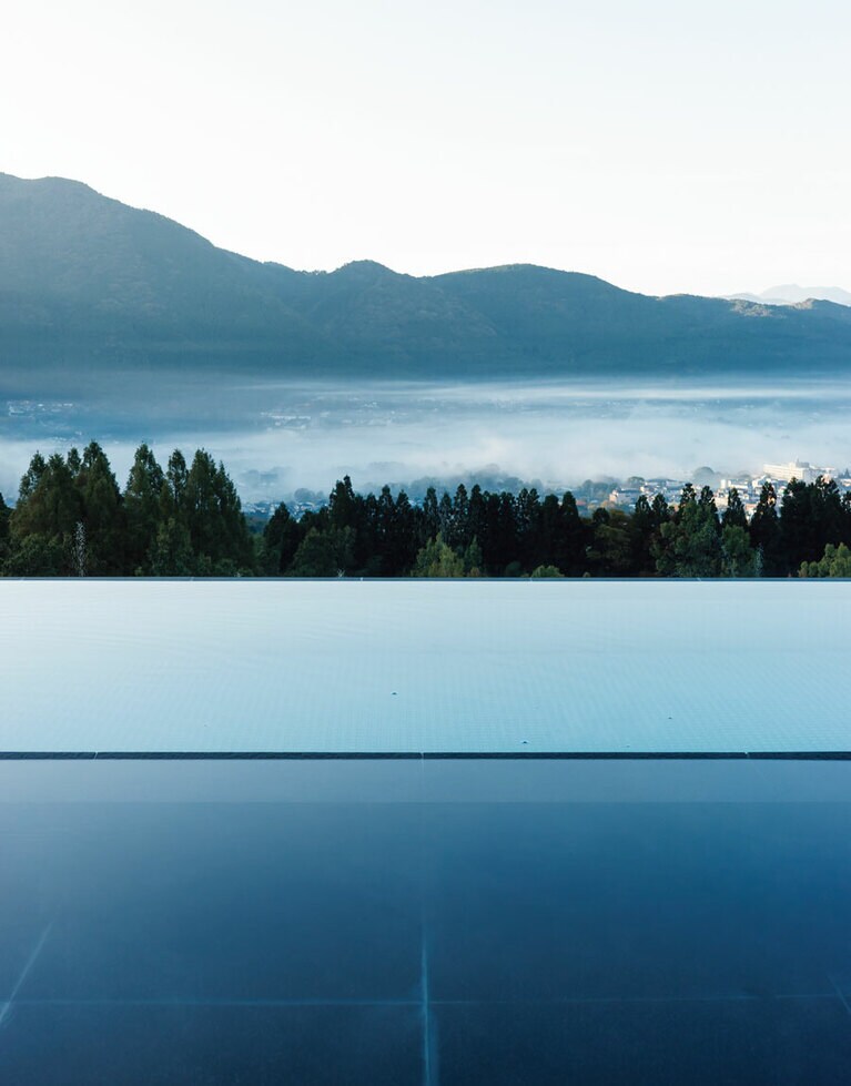 山越しの街並み、その向こうに山とダイナミックな眺望。