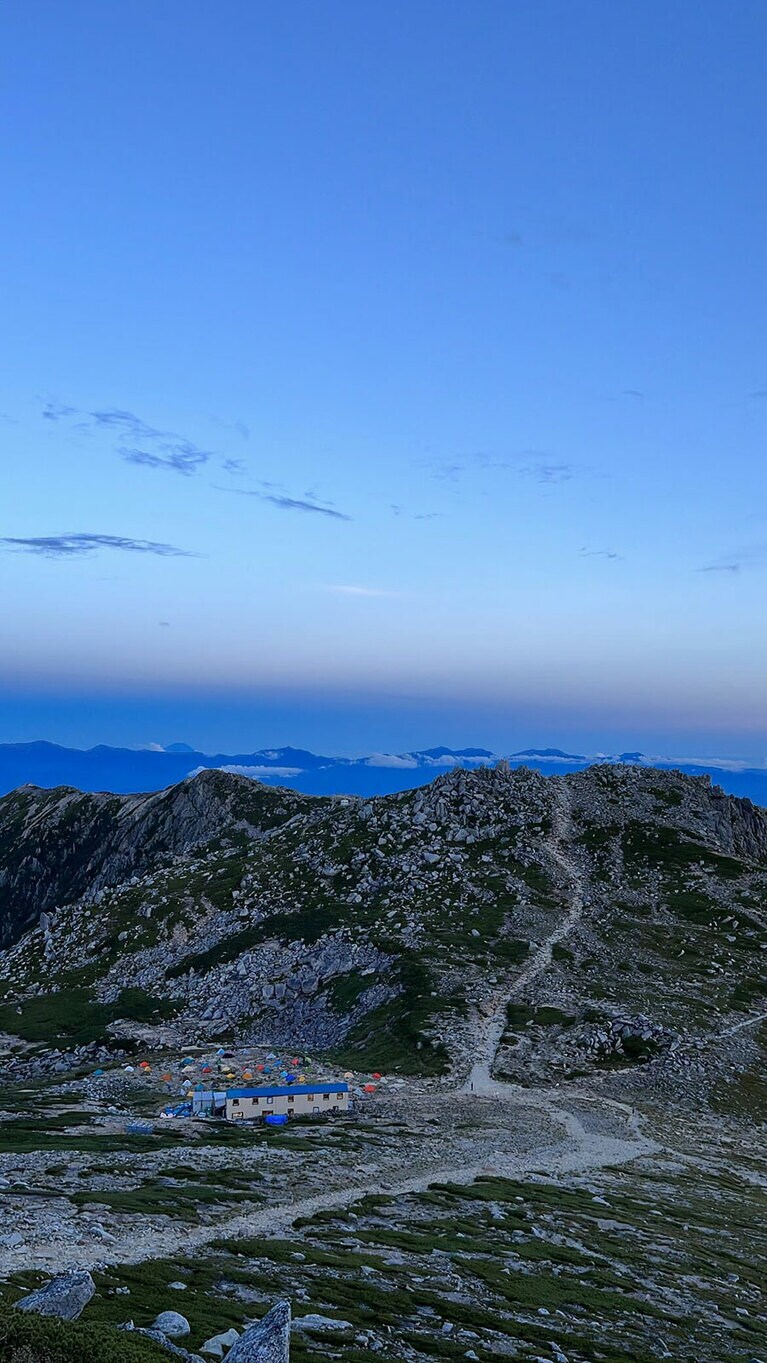 昼間の中央アルプス。眼下にカラフルなテントが。