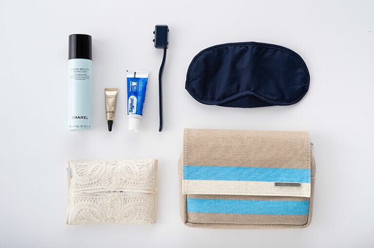 左上から時計回りに、シャネルの保湿美容液、シャネルのアイクリーム、シンガルの歯みがき粉、携帯歯ブラシ、アイマスク、KLMオランダ航空ビジネスクラスのアメニティのポーチ、ポケットティッシュ。