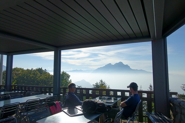 カフェで軽食や飲み物も楽しめる。この日は淡い雲海のようなもやがかかっていて、遠くの山が浮かんでいるかのように見えた。