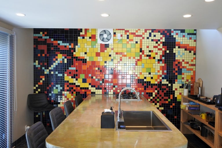 地層をイメージした、キッチンの壁を埋めるタイルのアート。