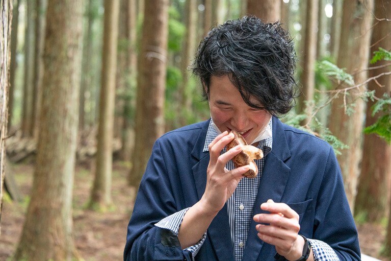 収穫したての原木椎茸の香りを試す東福シェフ。