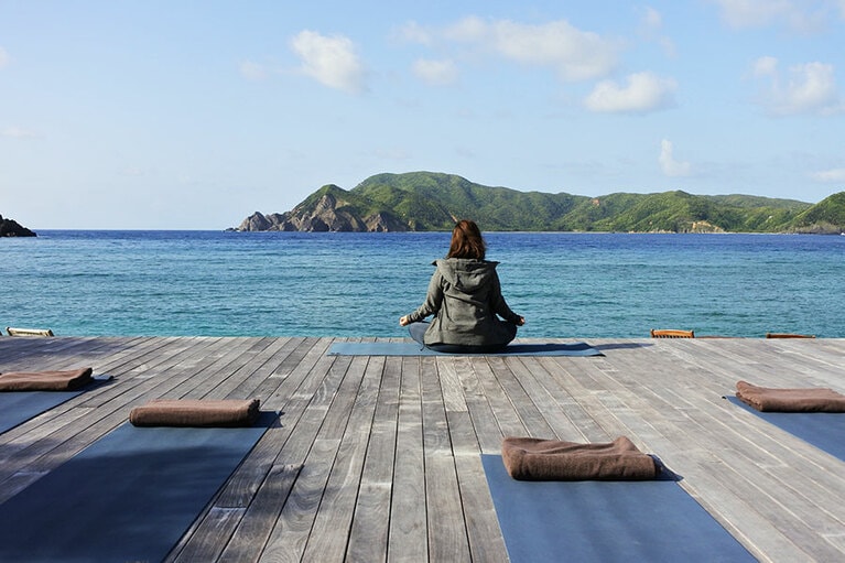 朝日を受け、海を前にしてサンライズヨガ。