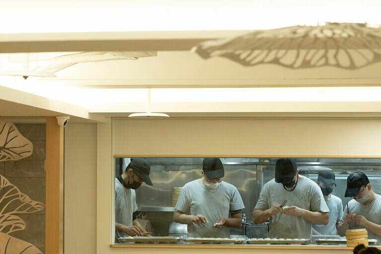 明るく清潔な厨房で点心づくりに励む若手スタッフたち。点心づくりの様子が眺められる。