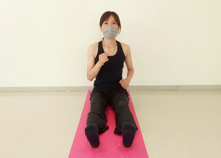 ヨガマットの端に座り、頭を高く保ったまま、しっかりと腕をふって歩き始める。