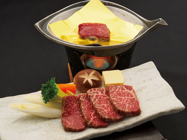 【はづ別館】鳳来牛ステーキプランの食事はステーキ、前菜、炊き合せ、焼物など全10品が付く。客室はスタンダードの8畳間または二間続きの民芸調の部屋が選べる。