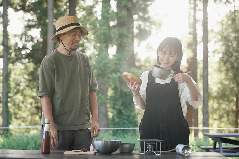 千秋さんが開発した「シェラどんぶり＆お釜ヘッド」を見て談笑するふたり。