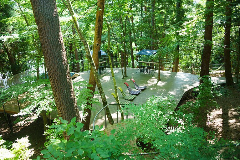 木漏れ日が心地よいデッキ。ロッキングチェアや空中ベンチで読書にふけるのもいい。