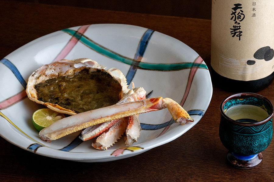 香ばしい焼き蟹と甲羅焼き。地酒のおすすめは季節限定酒「天狗舞 生酛仕込純米酒」。パンチのある味わいが蟹と絶妙にマッチする。