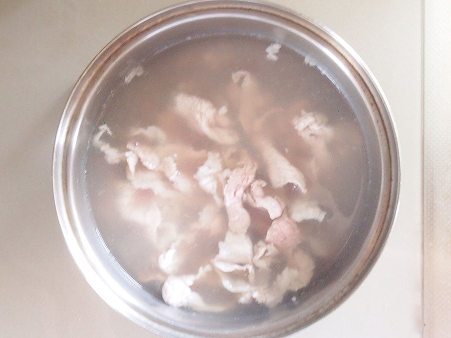 (4) 鍋に湯を沸かし、豚肉を入れて茹でます。赤みがなくなったらザルで湯切りし、冷まします。