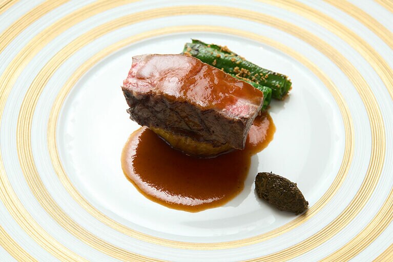 京都の亀岡産の丹波牛を香ばしくグリルした「丹波牛と加茂茄子 万願寺唐辛子」。ベッドのように敷かれた旬の加茂茄子は、分厚く取りジューシーに火入れしています。