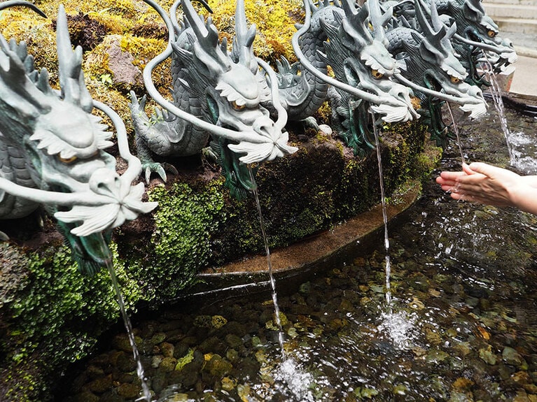 九頭龍神社新宮前の9つの龍の口からは、霊水・龍神水が流れ落ちる。