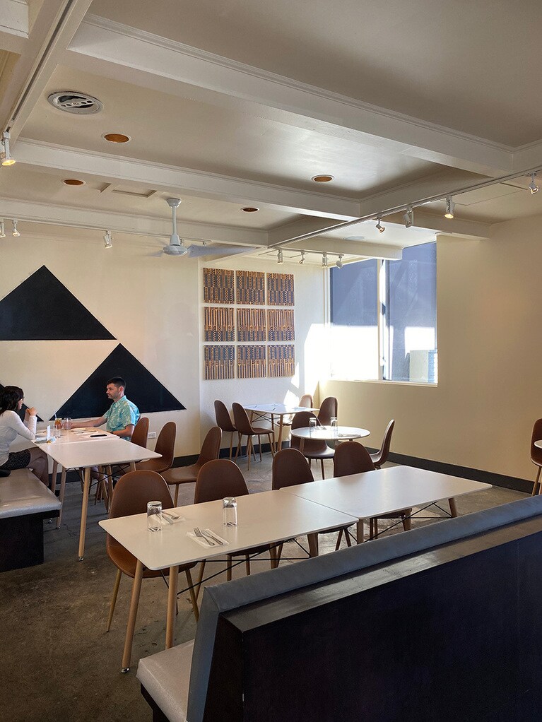 距離を保ち配置されたテーブル。壁には店名でもあるハワイ古来の生地カパをモチーフにしたディスプレイ。