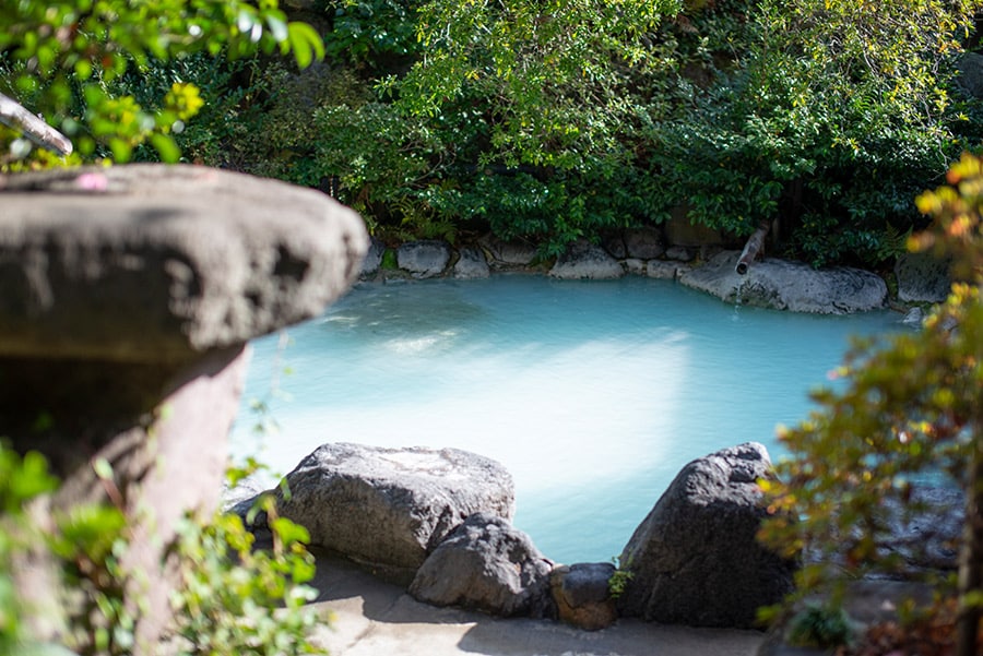 大分の別府明礬温泉　岡本屋旅館の庭園露天風呂。白濁した硫黄泉は美肌の湯といわれている。