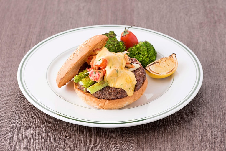 オスカースタイルバーガー 2,800円。クラブミート、アスパラガスを乗せ、卵黄とバターをベースに酸味をきかせたベアルネーズソースかけたステーキ、“オスカースタイル”をハンバーガーで表現。海の幸と大地の恵みを一度に楽しめる贅沢バーガー。