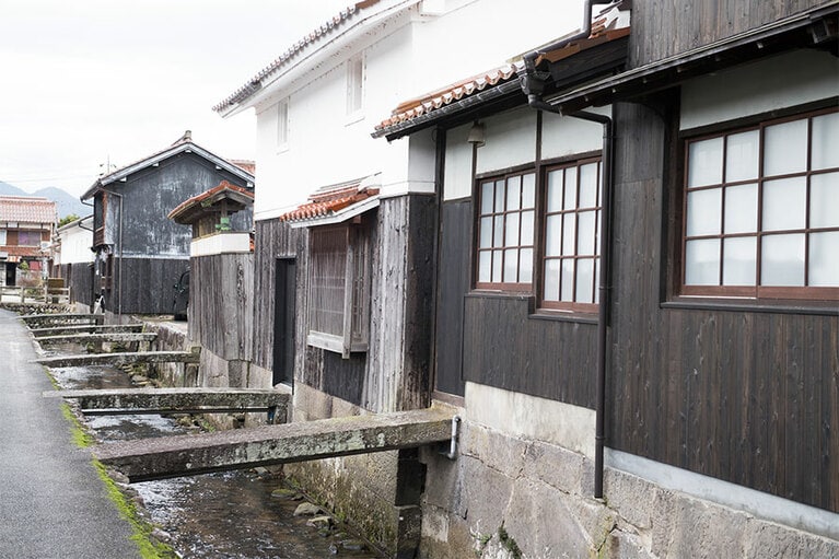 屋根瓦に漆喰壁、川のせせらぎ、その先にある山の緑。倉吉は観光スポットながらも、ほのぼのとした空気が漂う。