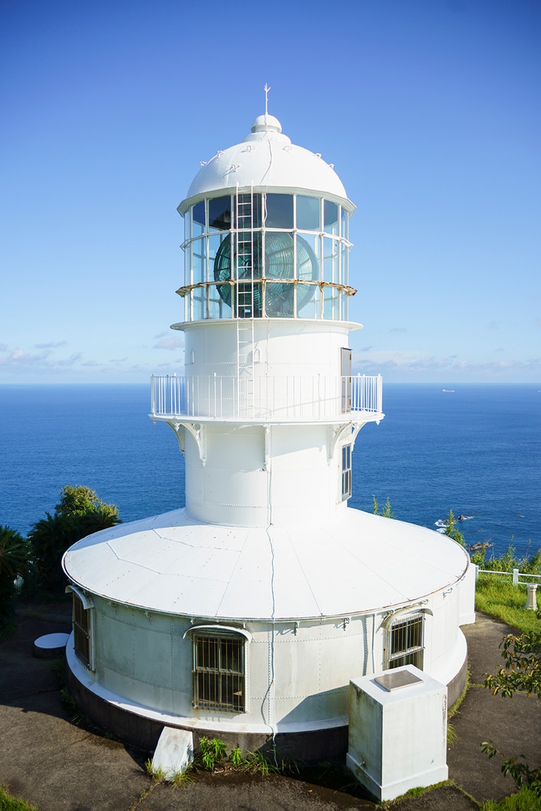 室戸岬灯台（高知県室戸市）。室戸岬の先端（標高151m）にあり、明治32年以来、航海者たちの安全を照らす水先案内人として活躍している。「恋人の聖地」の認定を受けており、その銘板が展望台に設置されている。