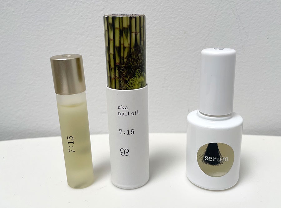 今回使ったウカの美容液「uka better nail serum」（3,520円／右）、オイル「uka nail oil」（全5種 3,410円～3,960円／左※真ん中の白い容器はオイルの外筒）。