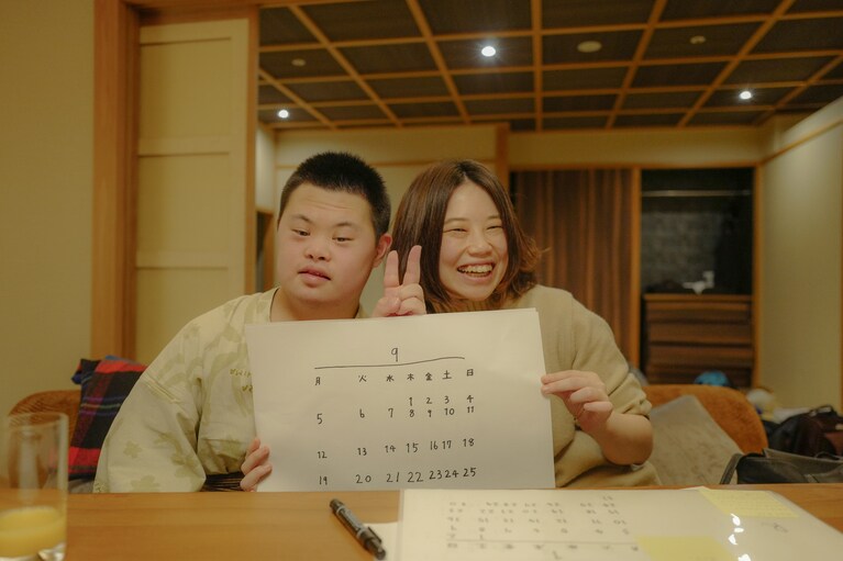 出来上がったカレンダーを手にする良太さんと奈美さん。