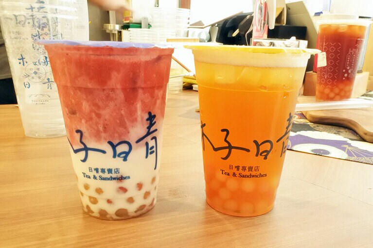 【木子日青 松山概念店】「手作珍珠包種青茶」(写真右)。カラフルなタピオカは少し大きめのサイズ。