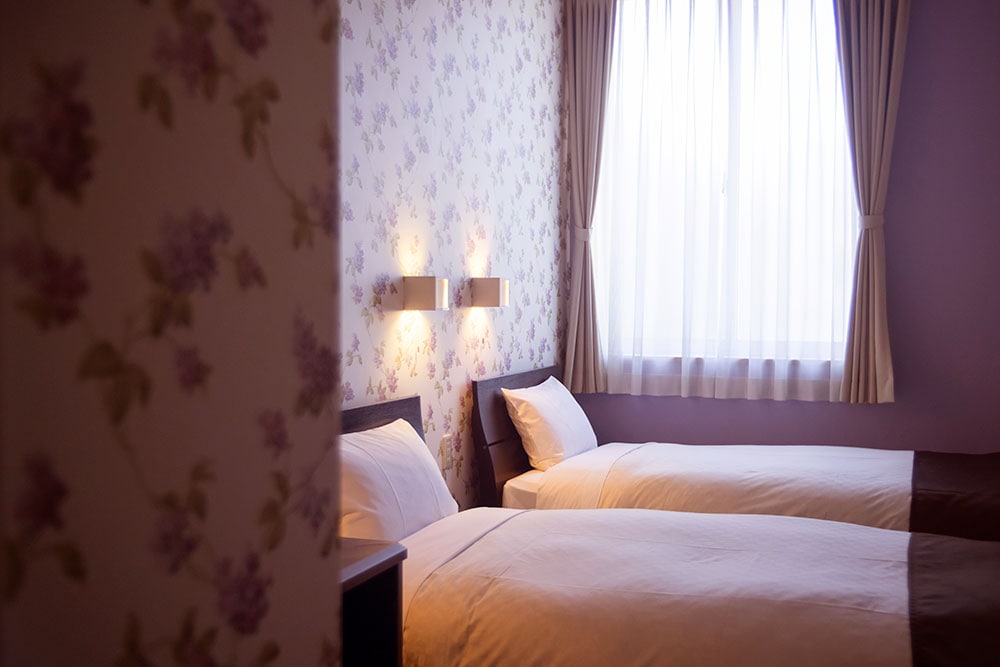 ホテルの内装デザインは一室ずつ異なる。シンプルな内装に、花柄の壁紙が映える。ホテルは一泊 5,500円(シングル・朝食付き)。