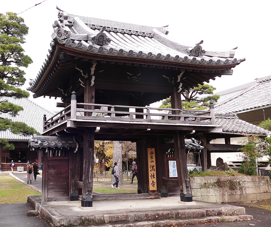 満性寺の鐘楼門をくぐる。