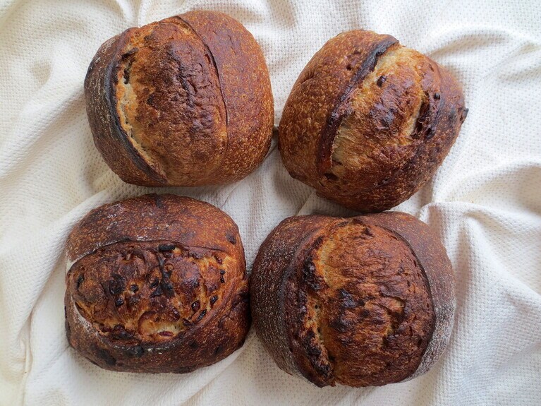 田舎パン。左上より時計回りに「全粒粉」「クルミ」「ライ麦」「クランベリー」いずれも1,200円、ハーフ600円。