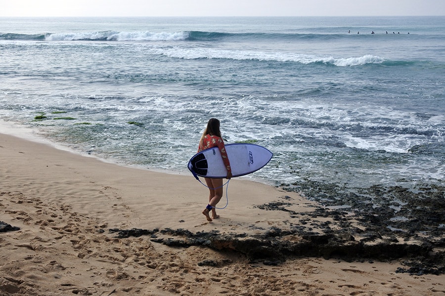 波を見定めて、さっそうと海へ向かう女性サーファー。