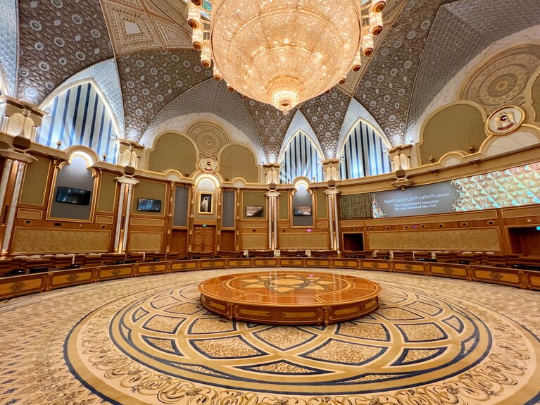 規模が大きすぎて写真ではわかりづらいが、円形の床の周囲にイスとテーブルが配置されている。座り心地のよさそうなイスは3列。国家レベルの重要会議の議場として使われる。シャンデリアには35万個のクリスタルが散りばめられていて、重さは12トン。ドーム型の天井には23Kの金箔が手作業で貼られている。