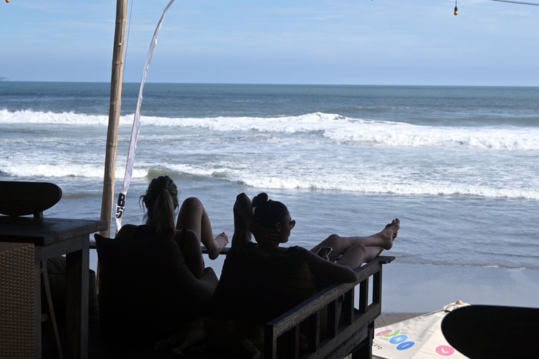 午後のひと時を過ごす女子。ただ海を眺めているだけの、ゆったりチル。