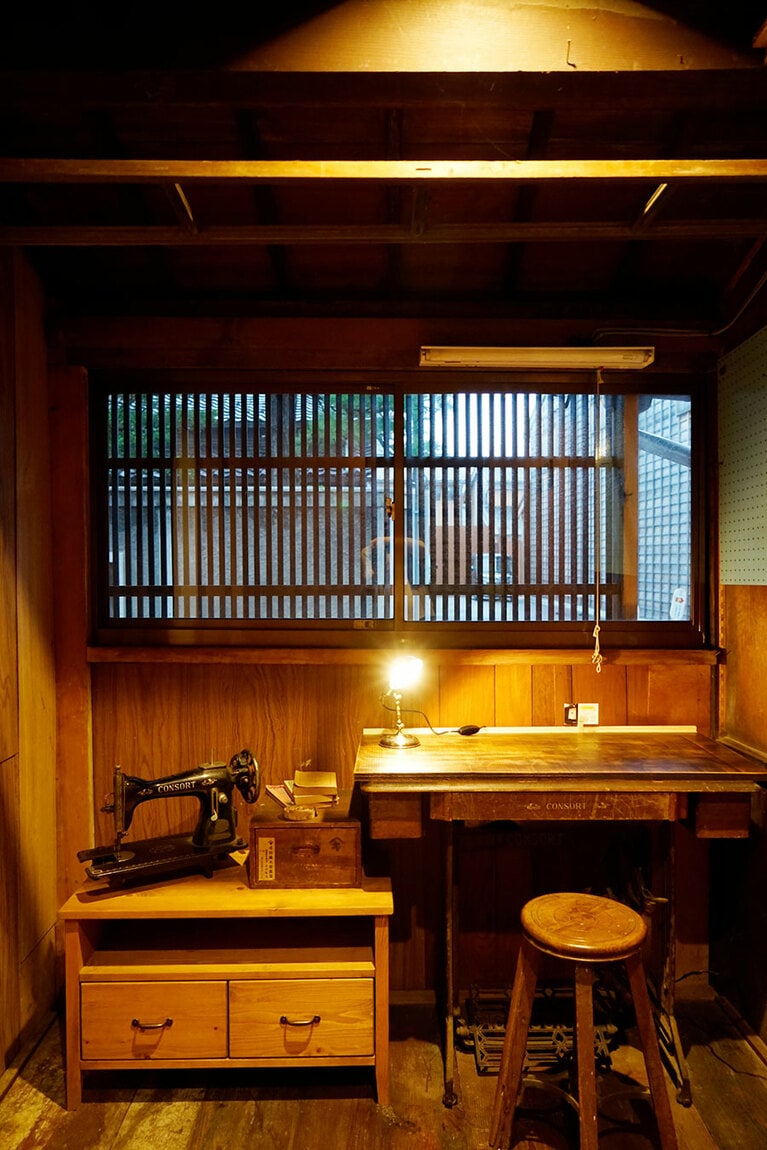 玄関の横にある小さな空間には古いミシンと小さなデスクが。wifiもあるのでリモートワークにぴったりだ。