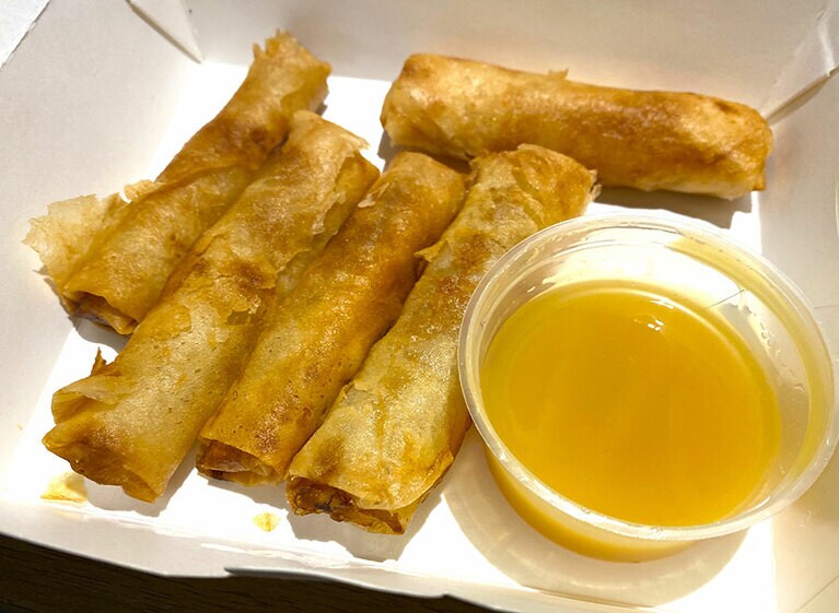持ち帰って食べたバナナ入り揚げ春巻き。マンゴー味のコンデンスミルクにつけて食べるというカロリーの塊。なのに止まらない、悪魔的なおいしさ。
