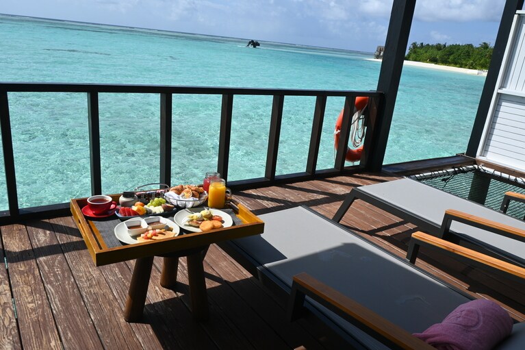朝食を運んでもらい、水上ヴィラのテラスで。“ダイン・バイ・デザイン”というサービスでは、ビーチにロマンティックなセッティングをアレンジしてもらうことも。