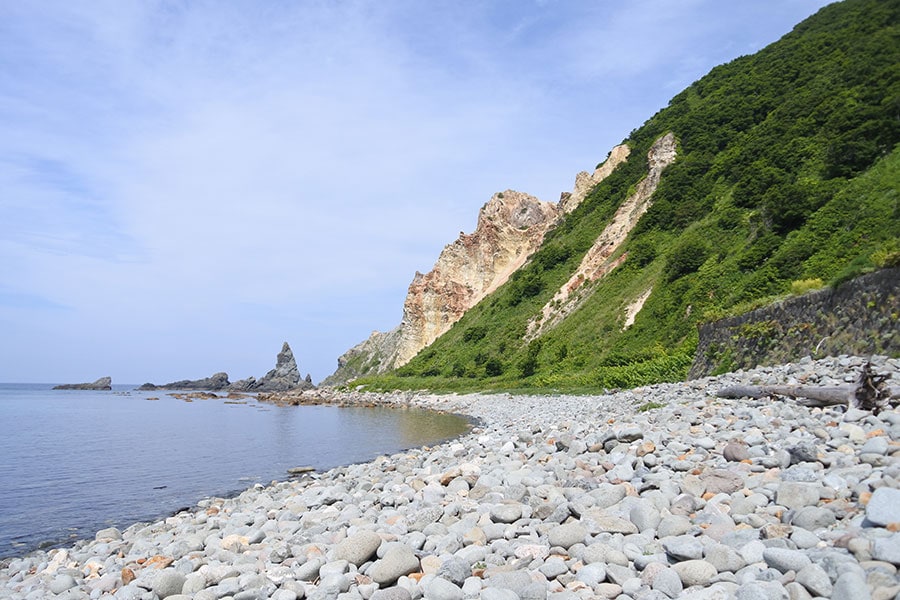 波打ち際は丸石が転がるゴロタ浜。海に向かって右側の断崖は一部、変色帯になっています。